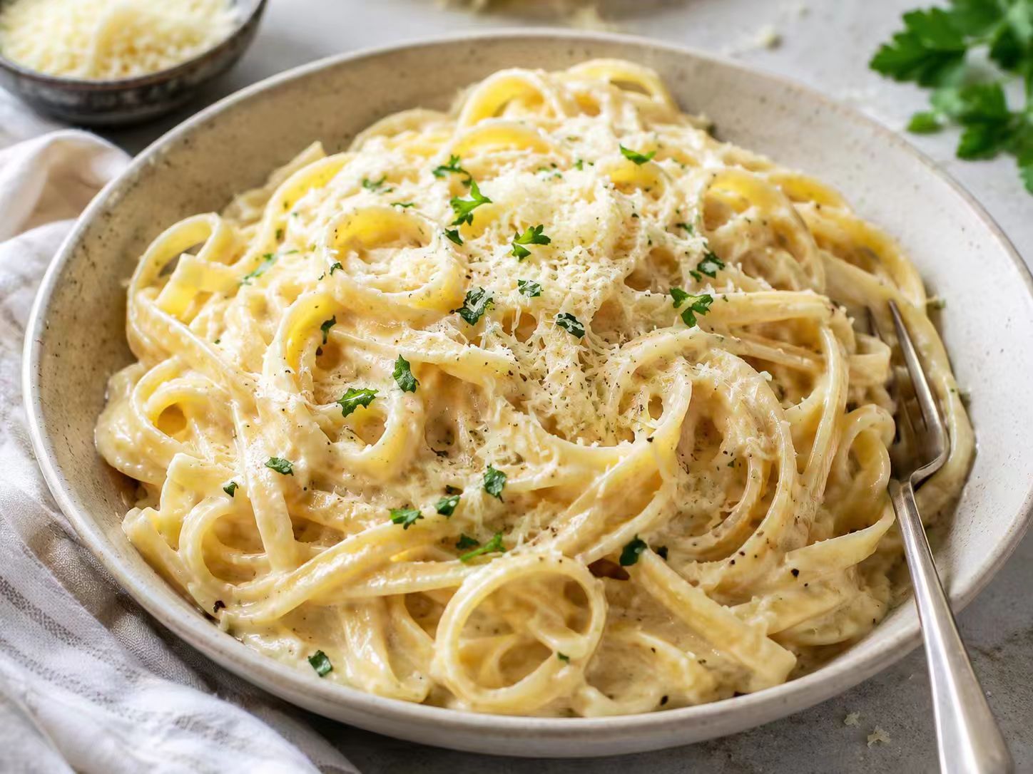 Creamy garlic parmesan pasta with parsley and grated cheese